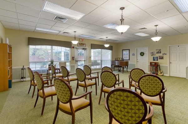 A well-lit conference room with neatly arranged chairs and large windows.