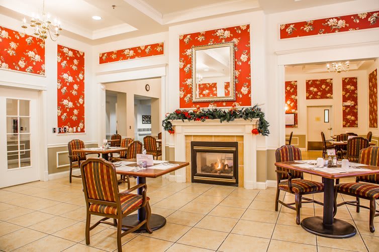 A cozy dining area with festive holiday decorations and a warm fireplace.
