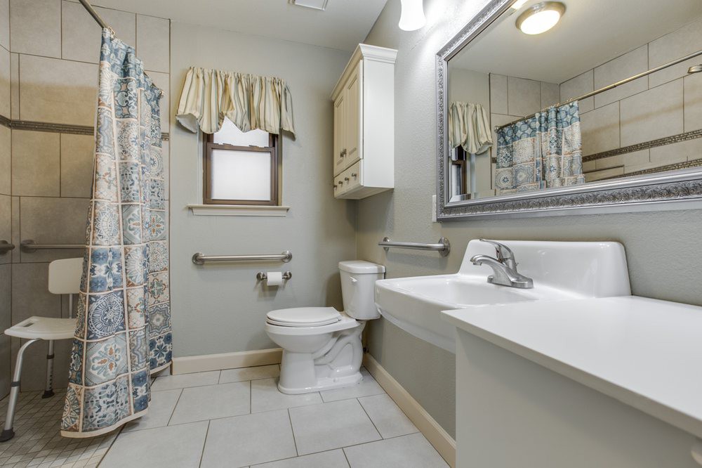 A clean and tidy bathroom with a toilet, sink, and shower curtain.
