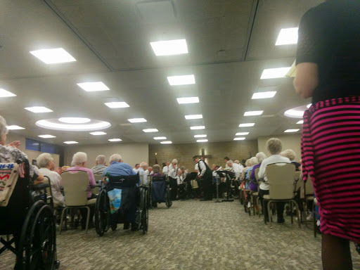 A large gathering of individuals seated at tables in a conference or event setting.
