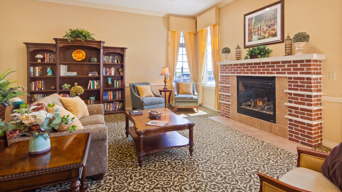 Cozy living room with a fireplace, bookshelf, and comfortable seating.