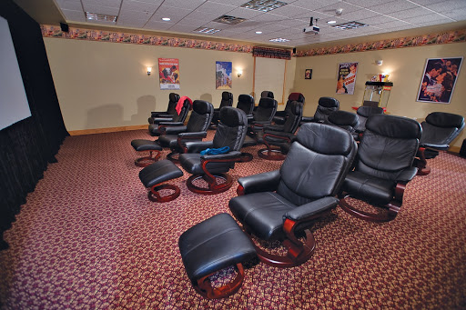 A cozy home theater featuring comfortable recliner chairs arranged for an optimal viewing experience.