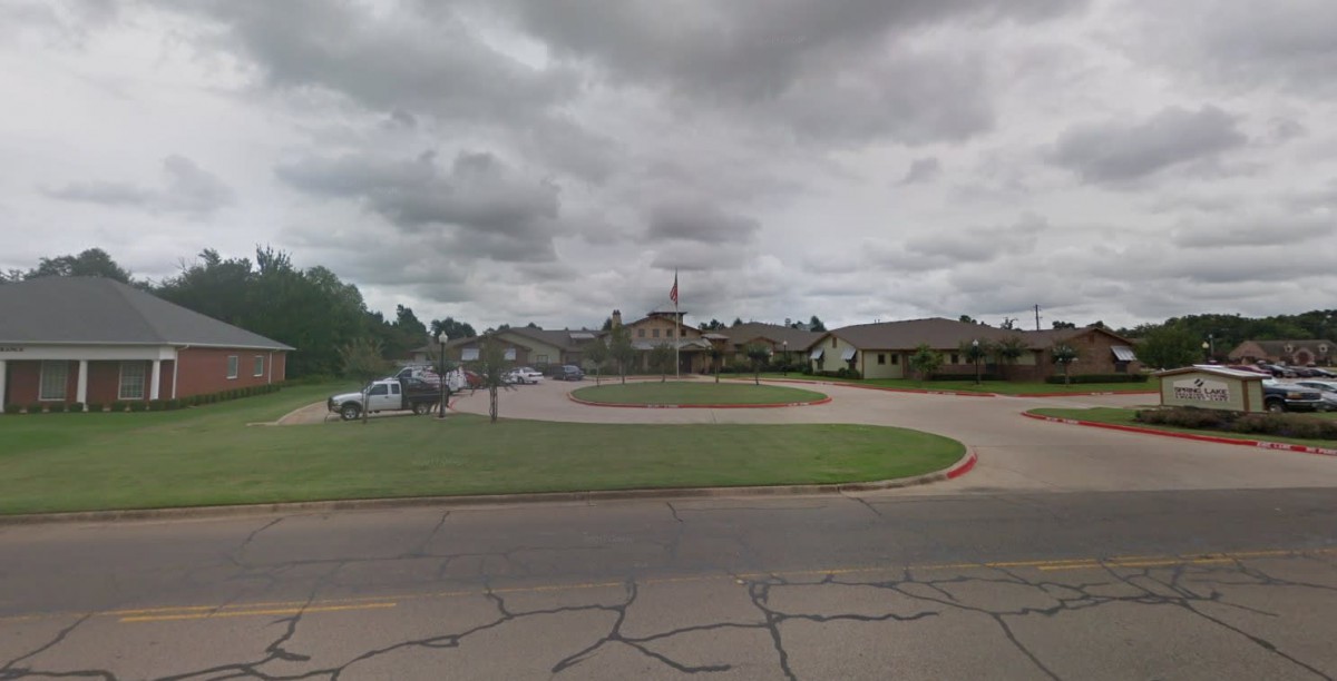 A cloudy day at a suburban road intersection with surrounding buildings.