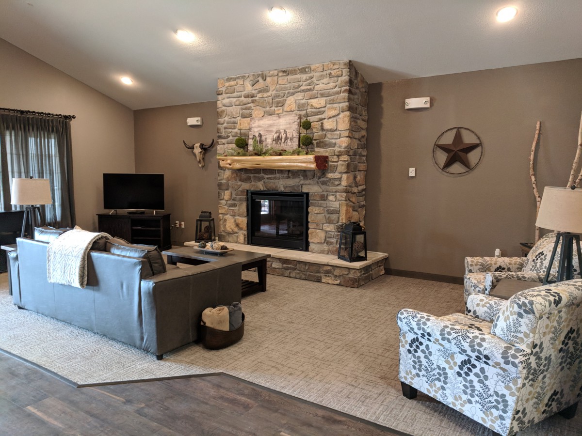 A cozy living room featuring a stone fireplace and comfortable seating.