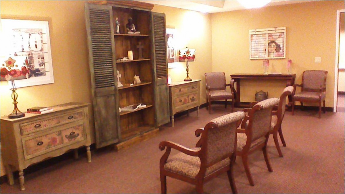 A cozy waiting room with comfortable chairs and a rustic bookshelf.