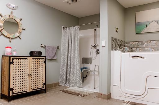 A modern bathroom featuring a shower area with a curtain, towel rack, and storage cabinet.