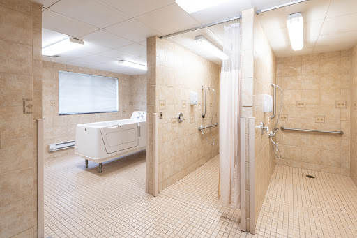 A clean and modern bathroom featuring multiple shower stalls and a laundry area.