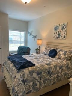 A cozy bedroom with floral bedding and soft lighting.