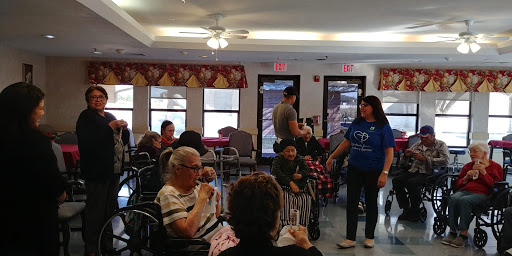 A lively gathering at a community center where staff engage with elderly residents.