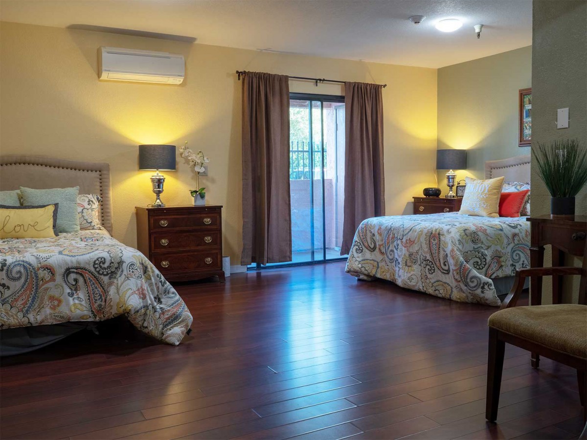 A cozy bedroom with two beds, nightstands, and soft lighting.