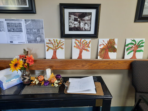 A display of colorful tree paintings along with seasonal decorations, adding a warm touch to the room.