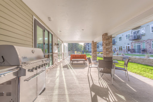 A spacious outdoor patio featuring a grill and comfortable seating, perfect for gatherings.