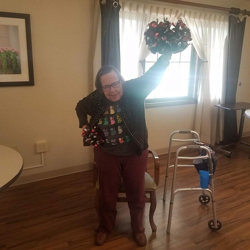 An elderly person joyfully celebrating in a cozy indoor setting.