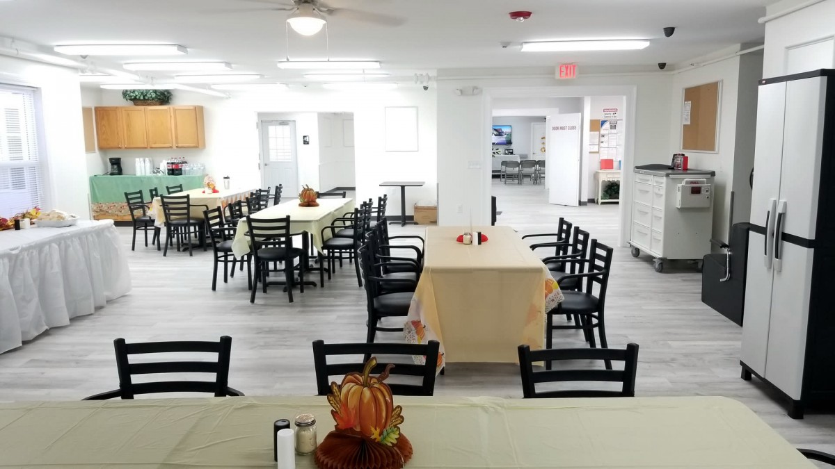 A community dining area with neatly arranged tables and chairs, adorned with festive decorations.