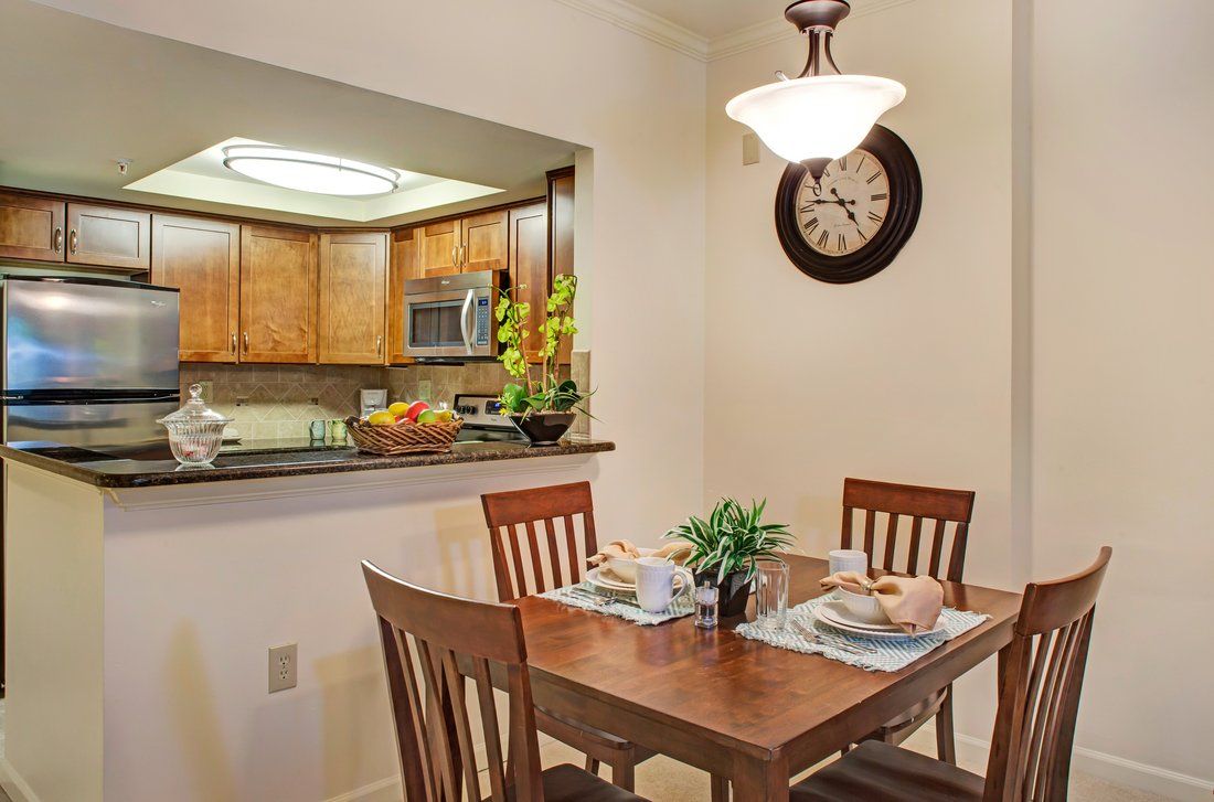 Cozy dining area with a wooden table set and an open view into the kitchen.
