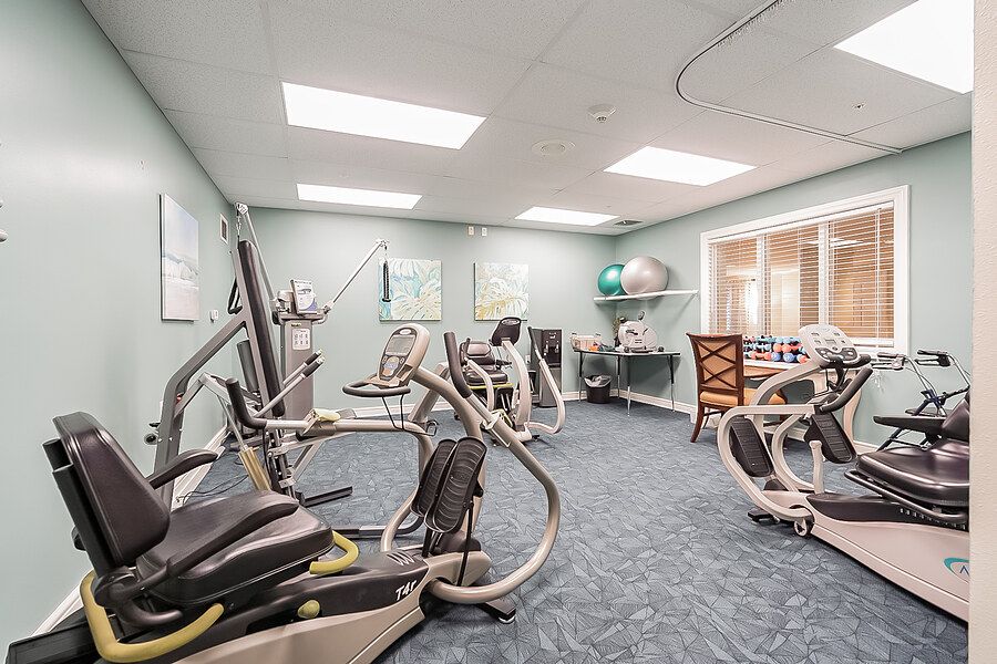 A well-equipped indoor gym with various exercise machines including treadmills and ellipticals.