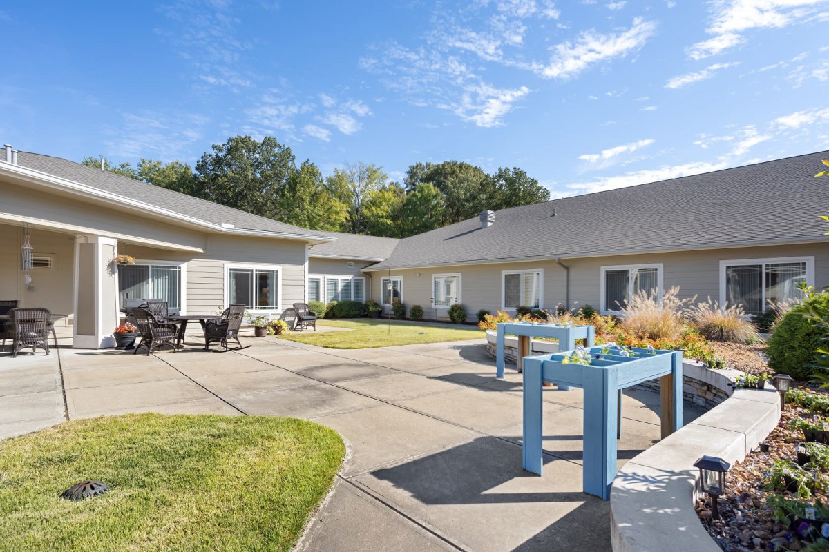 A view of a spacious courtyard with outdoor seating and landscaping on a sunny day.