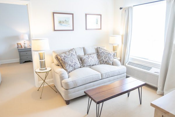 A cozy living room with a light-colored sofa, two lamps, and a wooden coffee table.