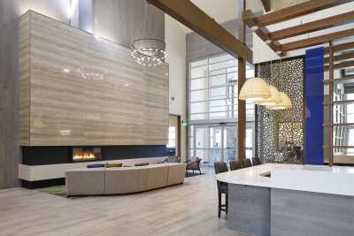 Modern lounge area with high ceilings and a large fireplace.
