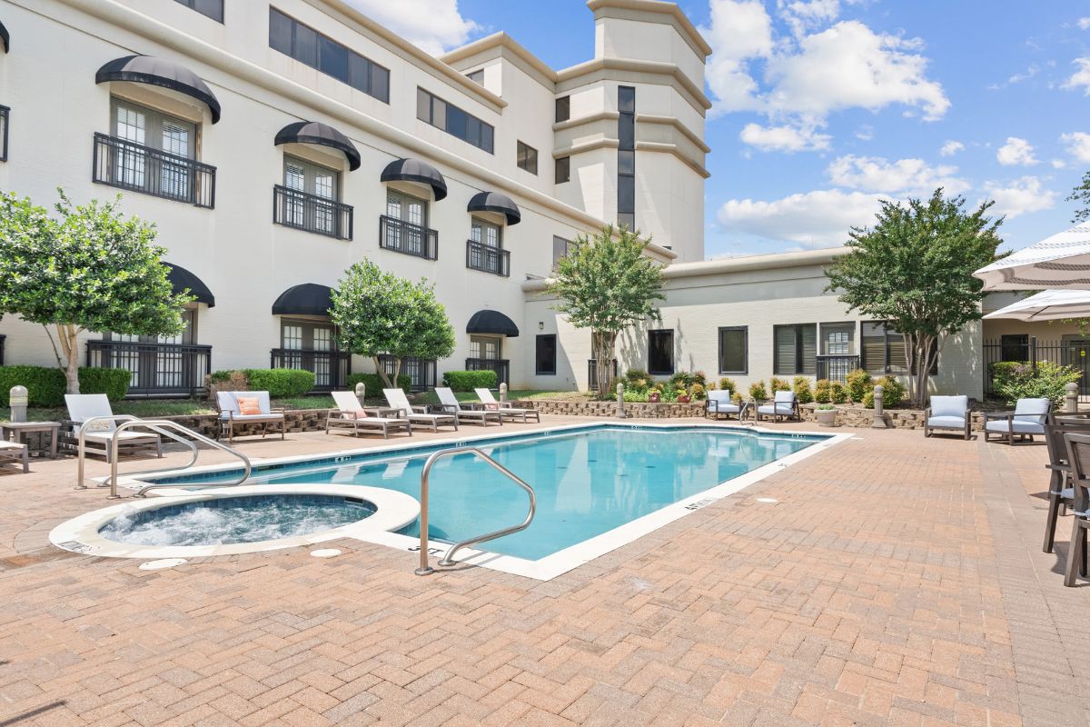 A tranquil outdoor swimming pool area at a hotel, perfect for relaxation on a sunny day.