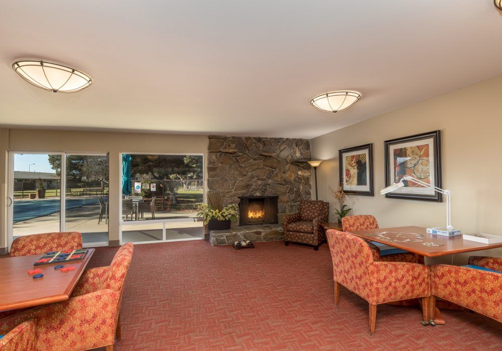 A cozy living room with a stone fireplace and comfortable seating.