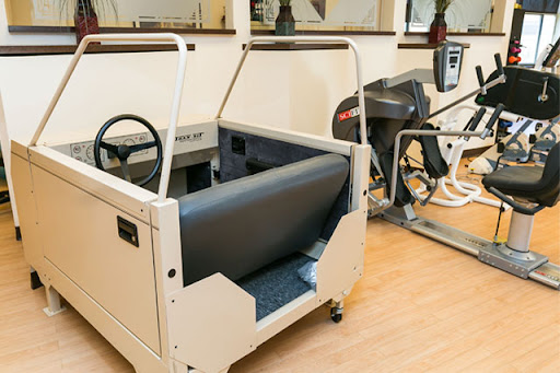 A motorized exercise machine designed for rehabilitation and physical therapy, located in a gym setting.