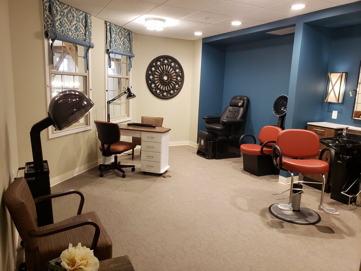 A cozy and well-decorated salon interior with comfortable seating and beauty stations.