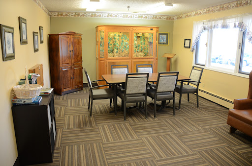 A well-furnished meeting room featuring a table, chairs, and decorative cabinet.