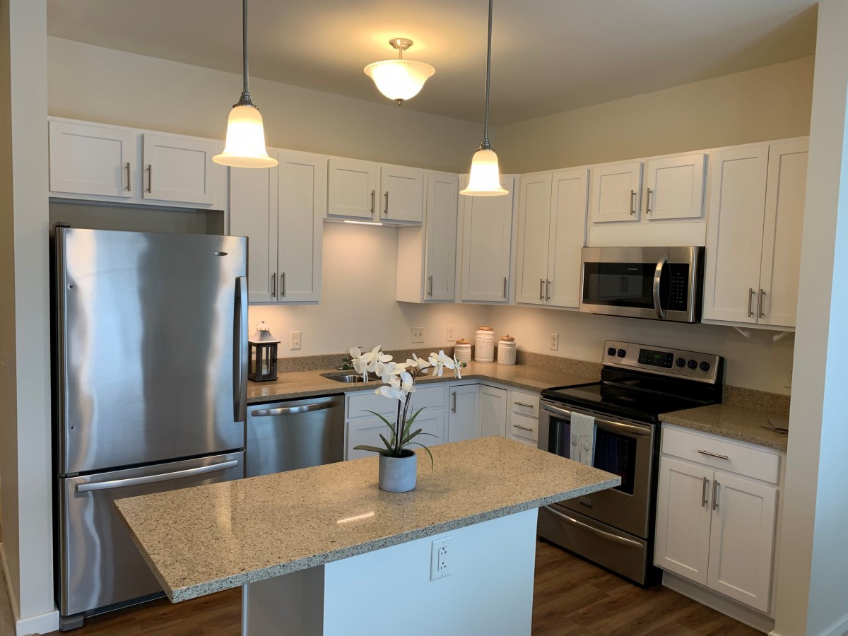 A modern kitchen with stainless steel appliances and an island.