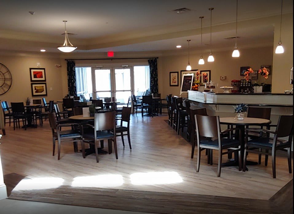 A cozy restaurant interior featuring dining tables, chairs, and a bar counter.