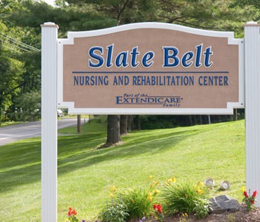 A sign for Slate Belt Nursing and Rehabilitation Center located outdoors.