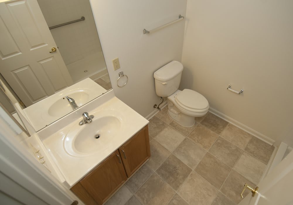A small bathroom with a sink, toilet, and mirror.