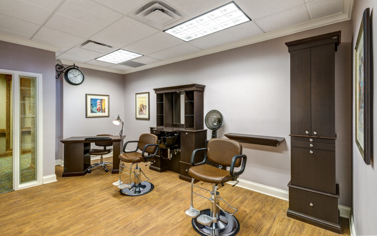 A modern barbershop interior with chairs and mirrors.