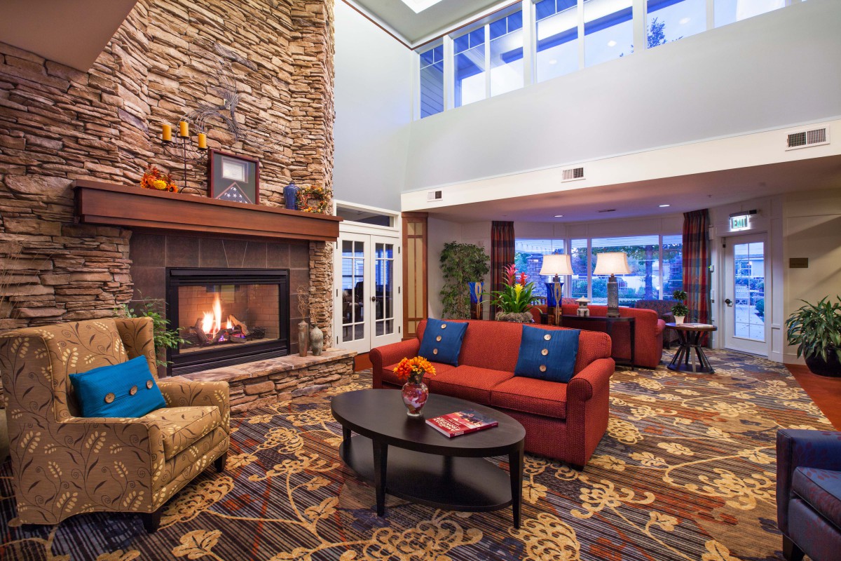 A cozy hotel lobby featuring a warm fireplace and comfortable seating area.