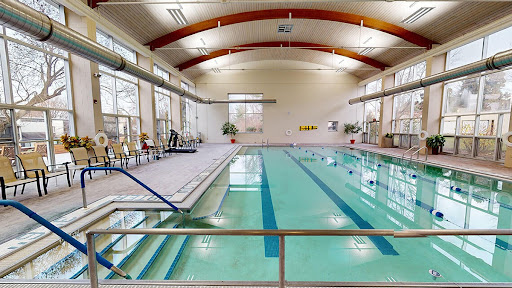 A spacious indoor swimming pool equipped for recreation and fitness activities.