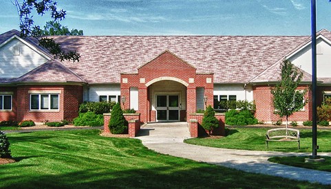 A welcoming brick building with a landscaped entrance.