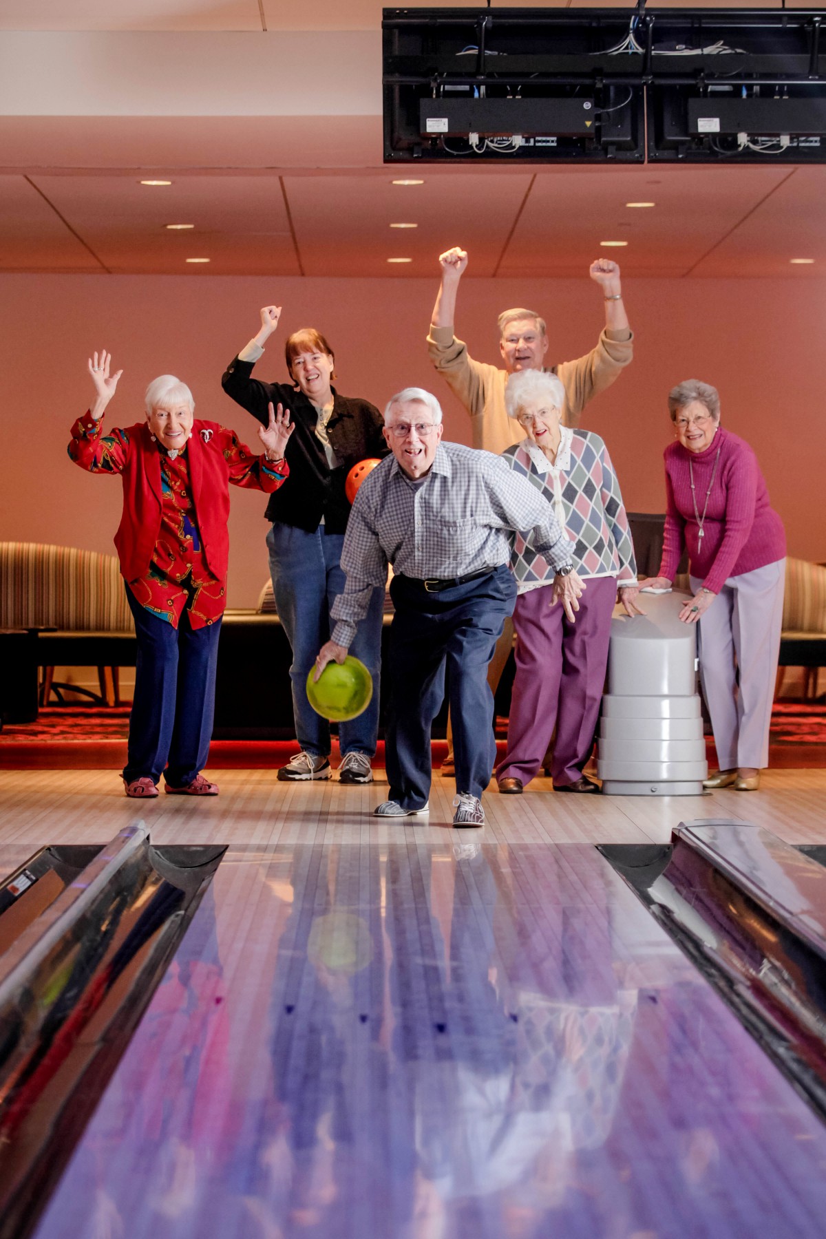 A group of seniors enjoying a lively game of bowling together.