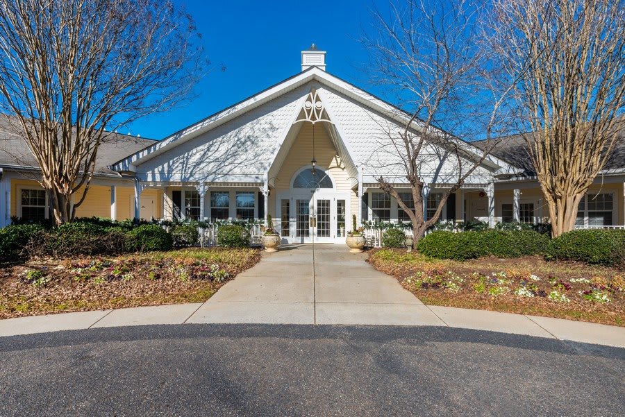 Front view of a building with a peaked roof and landscaped surroundings.