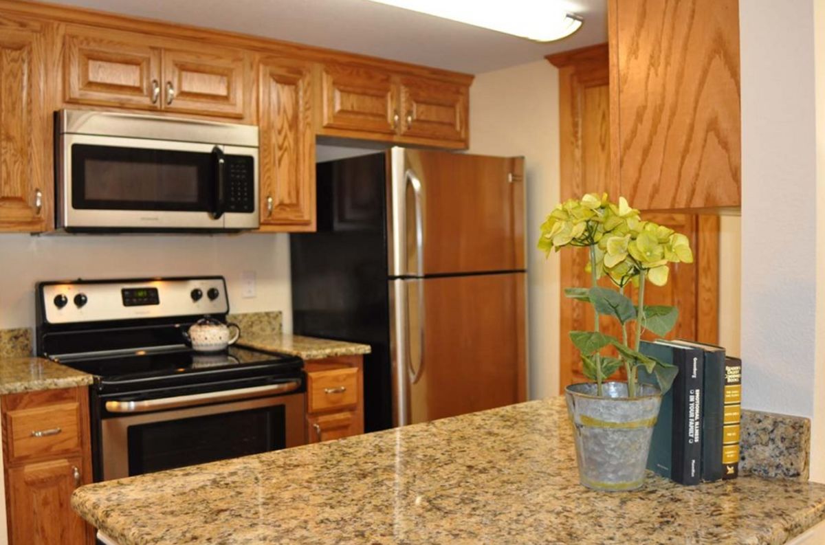 A modern kitchen featuring wooden cabinets and stainless steel appliances.