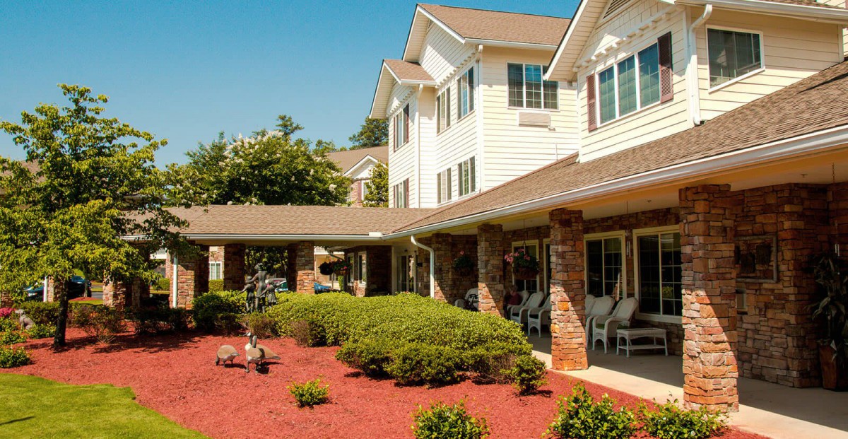 A well-maintained residential building with a garden and porch area.