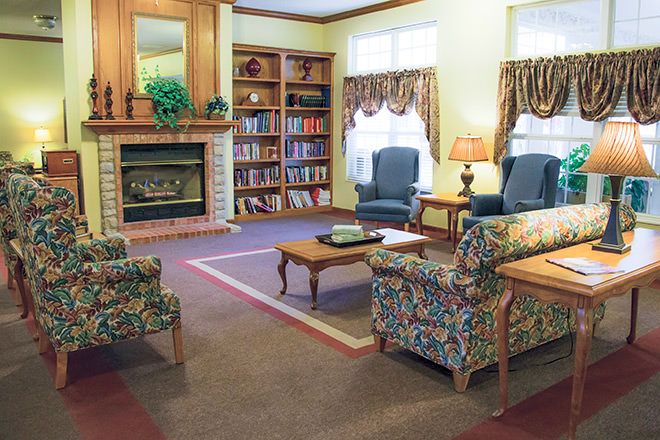 A cozy living room with a fireplace, bookshelves, and comfortable seating.
