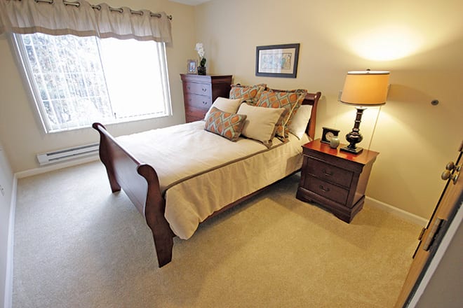 A cozy bedroom with wooden furniture and warm lighting.
