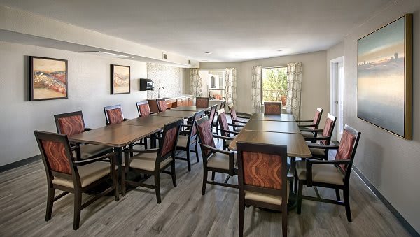 A well-lit conference room with tables and chairs arranged for a meeting.