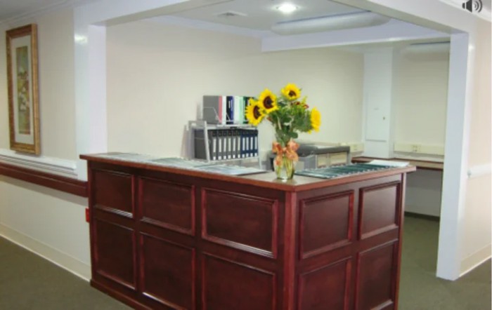 A reception desk with a vase of sunflowers in an office setting.