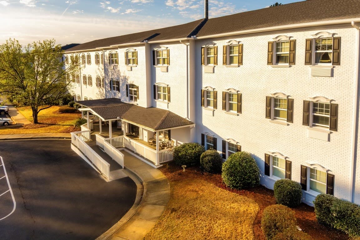 A large, elegant hotel building with classic architecture basking in the warm glow of sunset.