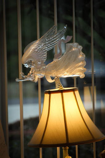 A beautifully crafted lamp featuring a glass eagle sculpture perched on its shade.