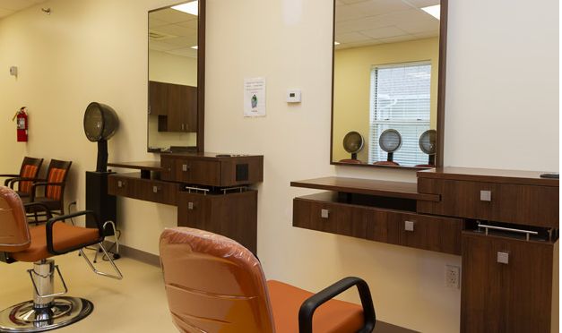 An empty beauty salon interior with chairs and mirrors.