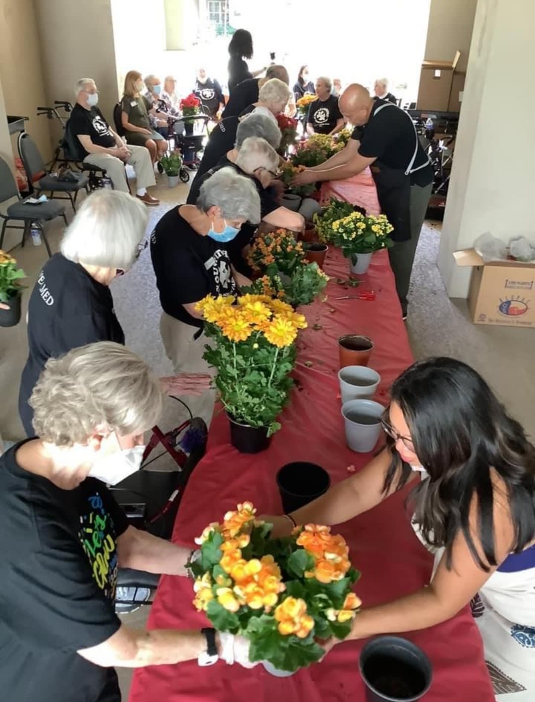 A group of people participating in a flower arranging workshop indoors.