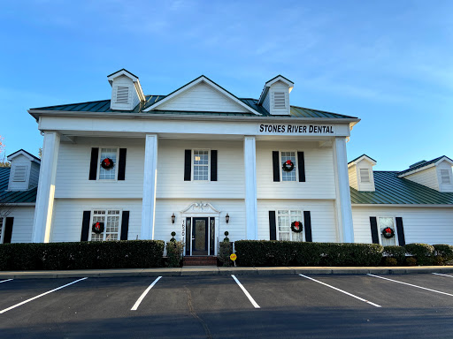 A beautiful white building with classic architectural features and a well-maintained landscape.
