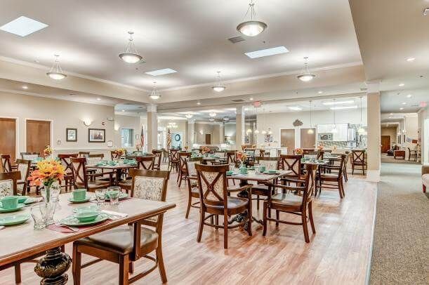 A spacious and well-lit dining area with neatly arranged tables and chairs.